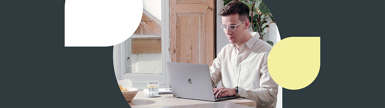 Man works at laptop by sunny window