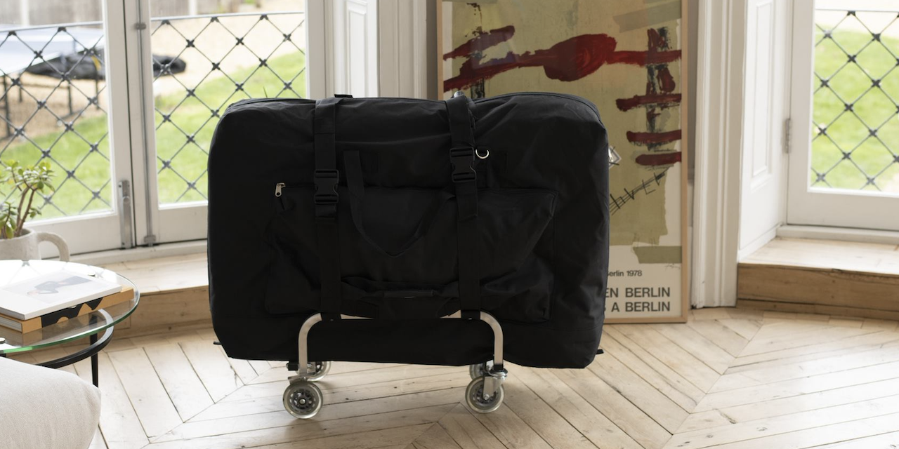 A mobile massage table in front of a window on a wooden floor