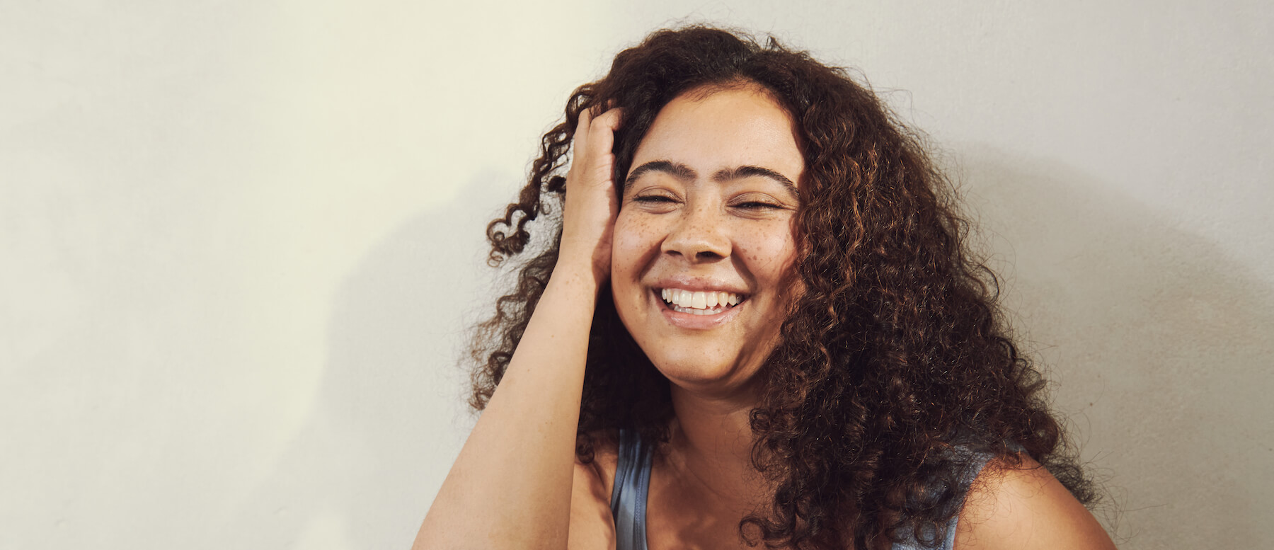 woman with freckles smiling in sunlight