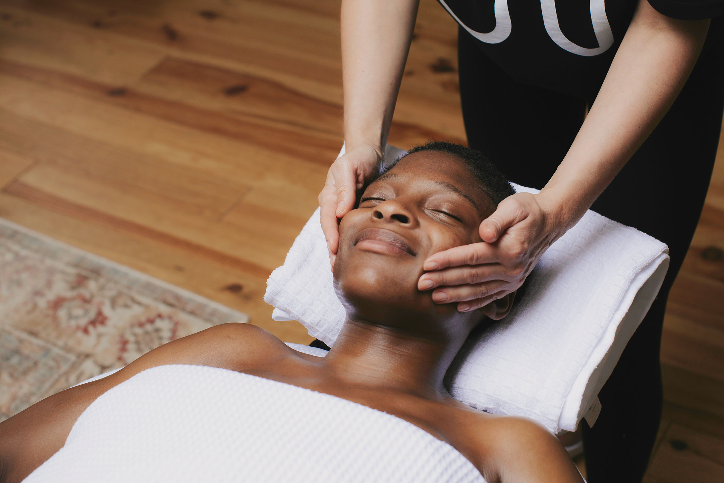 Customer Destiny smiling while getting a facial massage