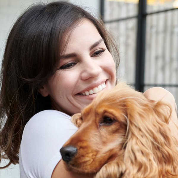Smiling woman with freshly waxed face, at home with her dog