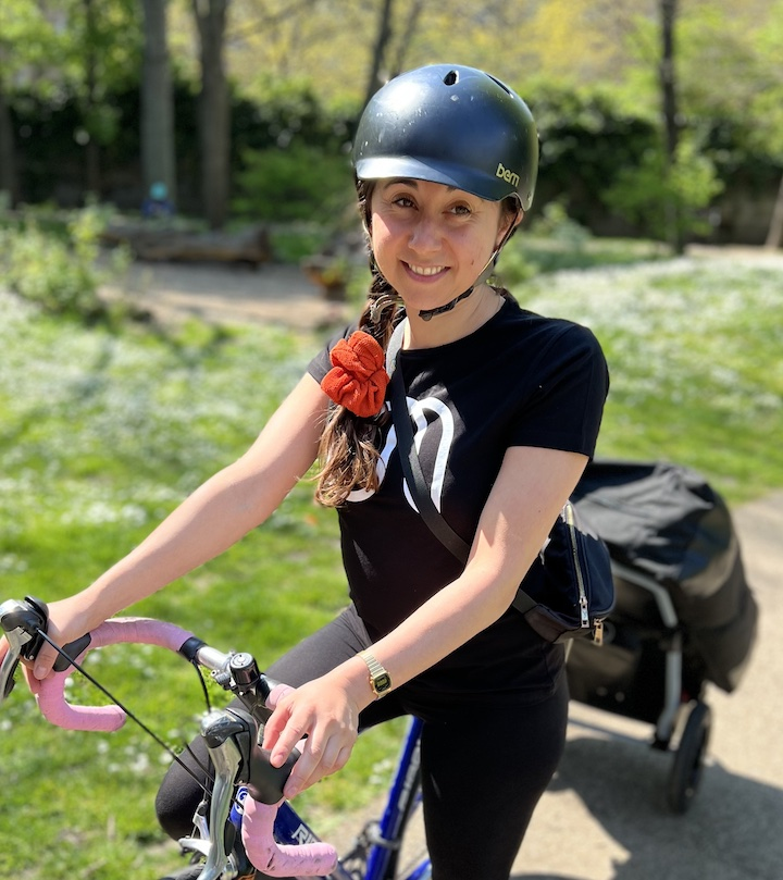 Woman on bike towing a massage table 