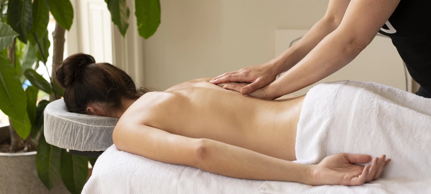 Client enjoys a Swedish massage in an apartment with leafy houseplants 