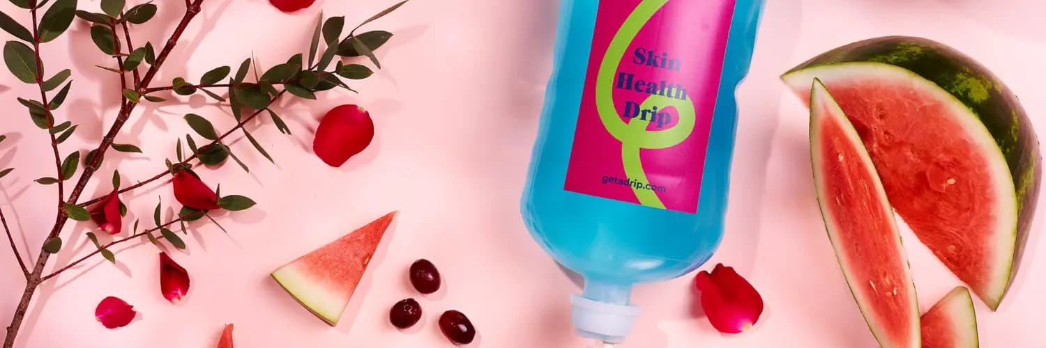 Get A Drip Skin Health Drip surrounded by watermelon, grapes and petals