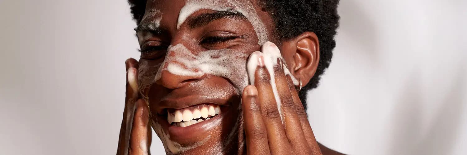 Male rubbing in foamy mask into skin