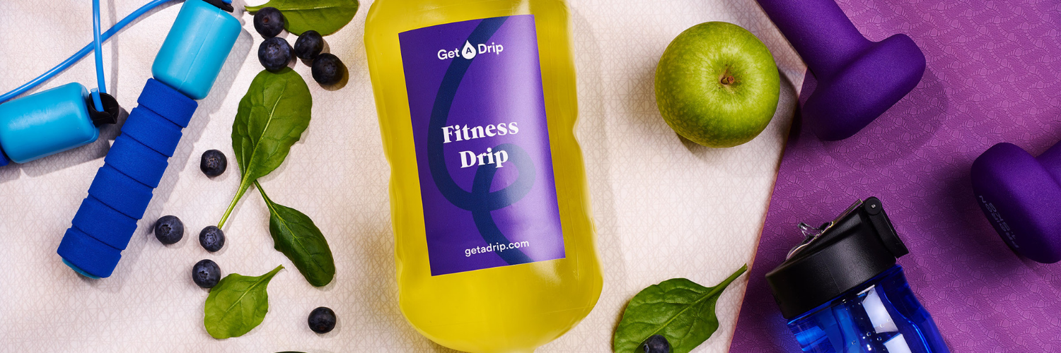 Urban Get A Drip Fitness Drip surrounded by weights, apples, leaves and blueberries