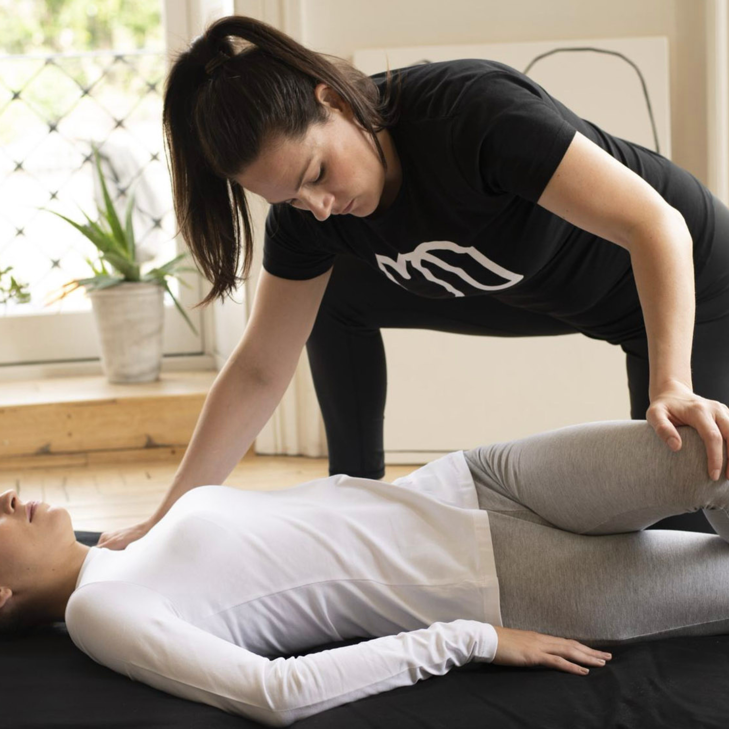 Therapist performs side body stretch during an at home assisted stretching session
