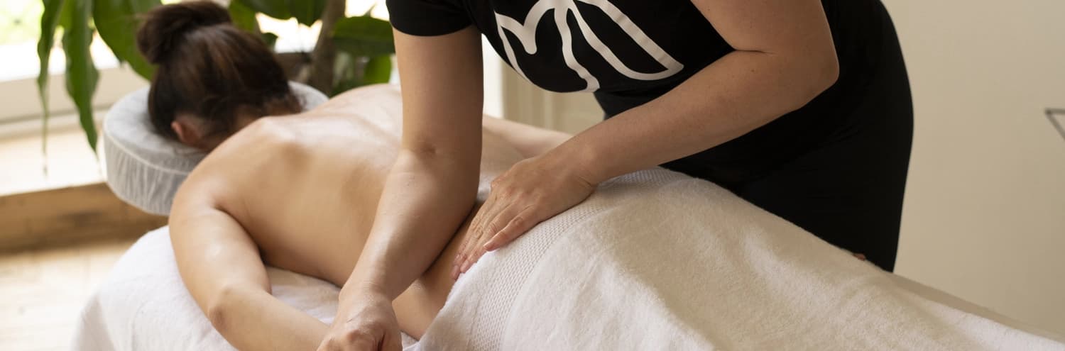 A client enjoys a deep tissue massage with the therapist using her elbow and forearm