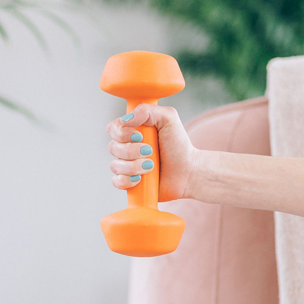 Manicured hand with blue nails holding an orange exercise weight