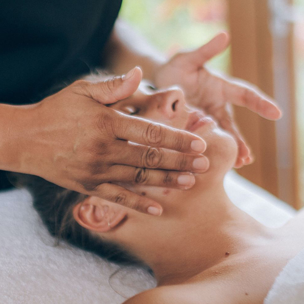 Therapist massaging person's face