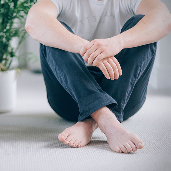 Man sitting cross-legged with pedicured feet