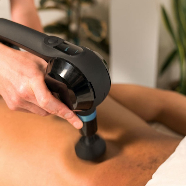 Muscle massage using Theragun® device on lower back 
