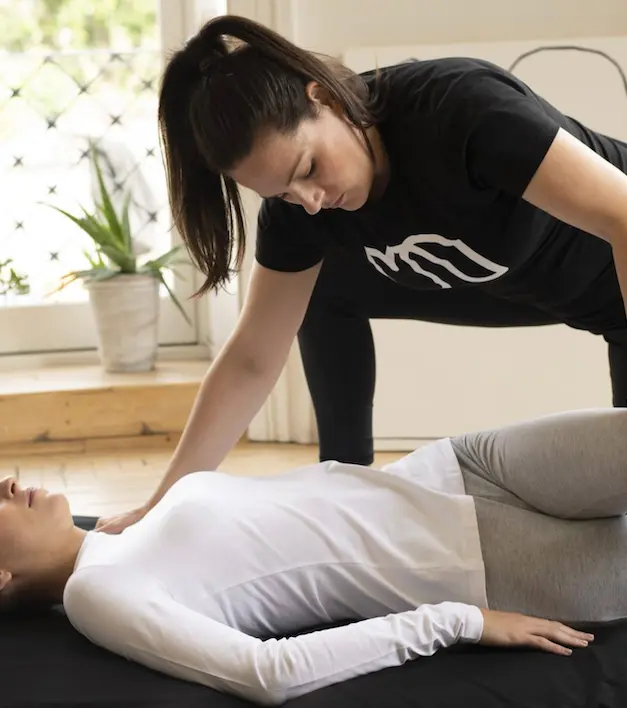 Therapist stretches client during an assisted stretching session at home