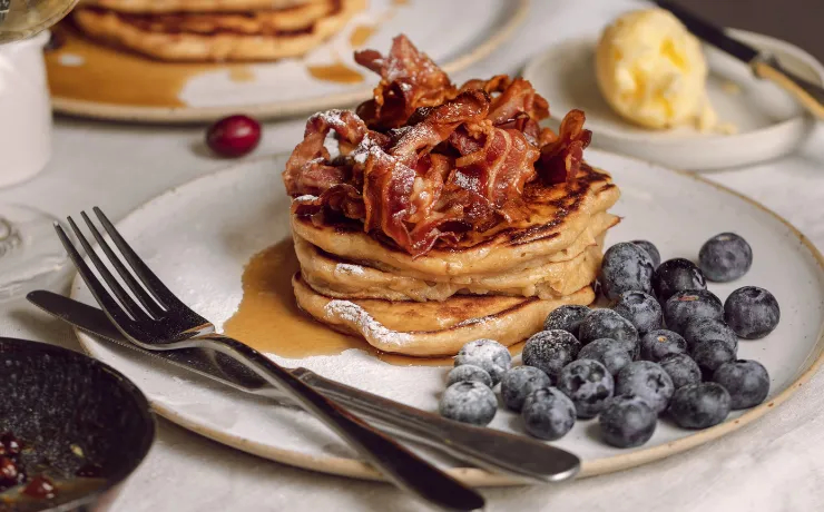 Fluffy Amercian style pancakes with bacon and blueberries