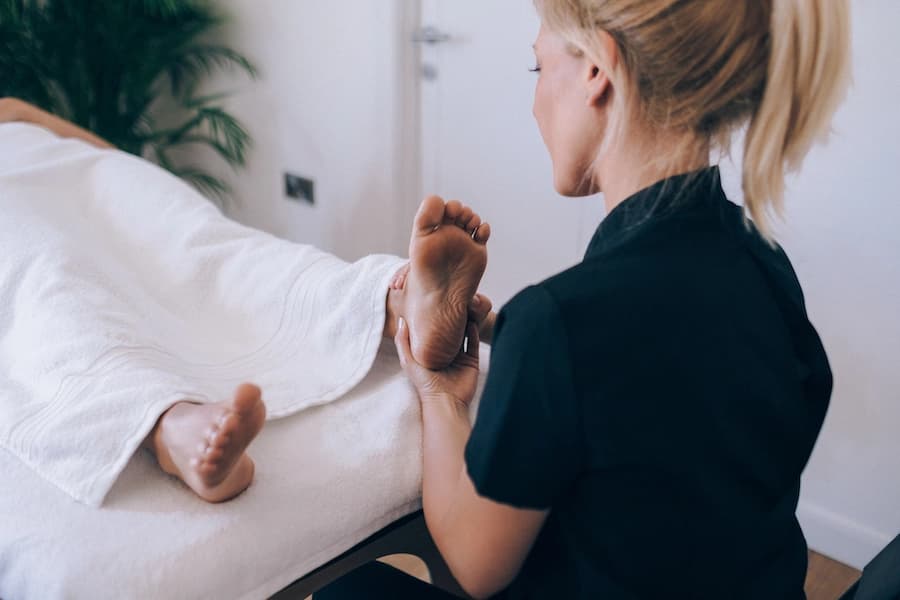 Therapist massages feet during foot reflexology appointment